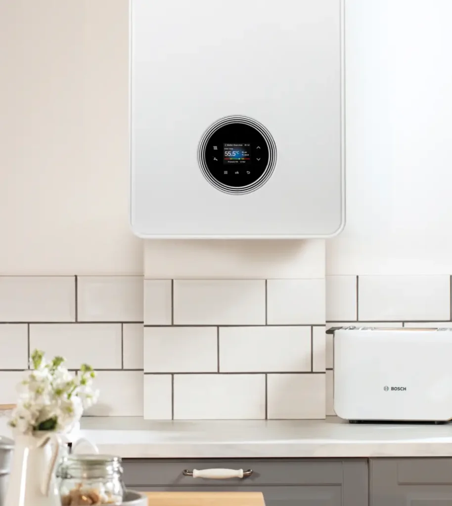 Modern white kitchen with a wall-mounted boiler featuring a digital display, white subway tile backsplash, a Bosch toaster, and a flower vase on the countertop—creating an inviting atmosphere in your home.